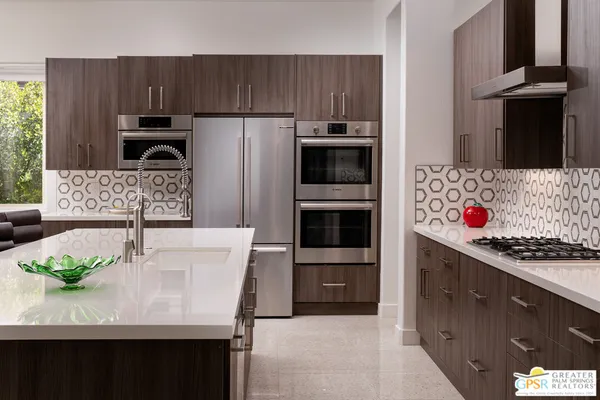 a kitchen with stainless steel appliances a stove a microwave a sink and cabinets