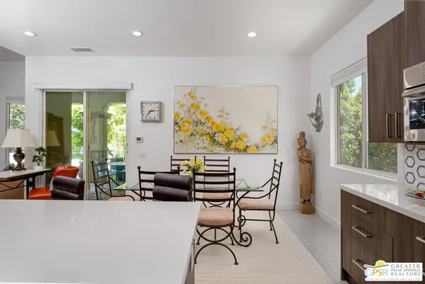 a kitchen with stainless steel appliances kitchen island granite countertop a stove a sink a dining table and chairs
