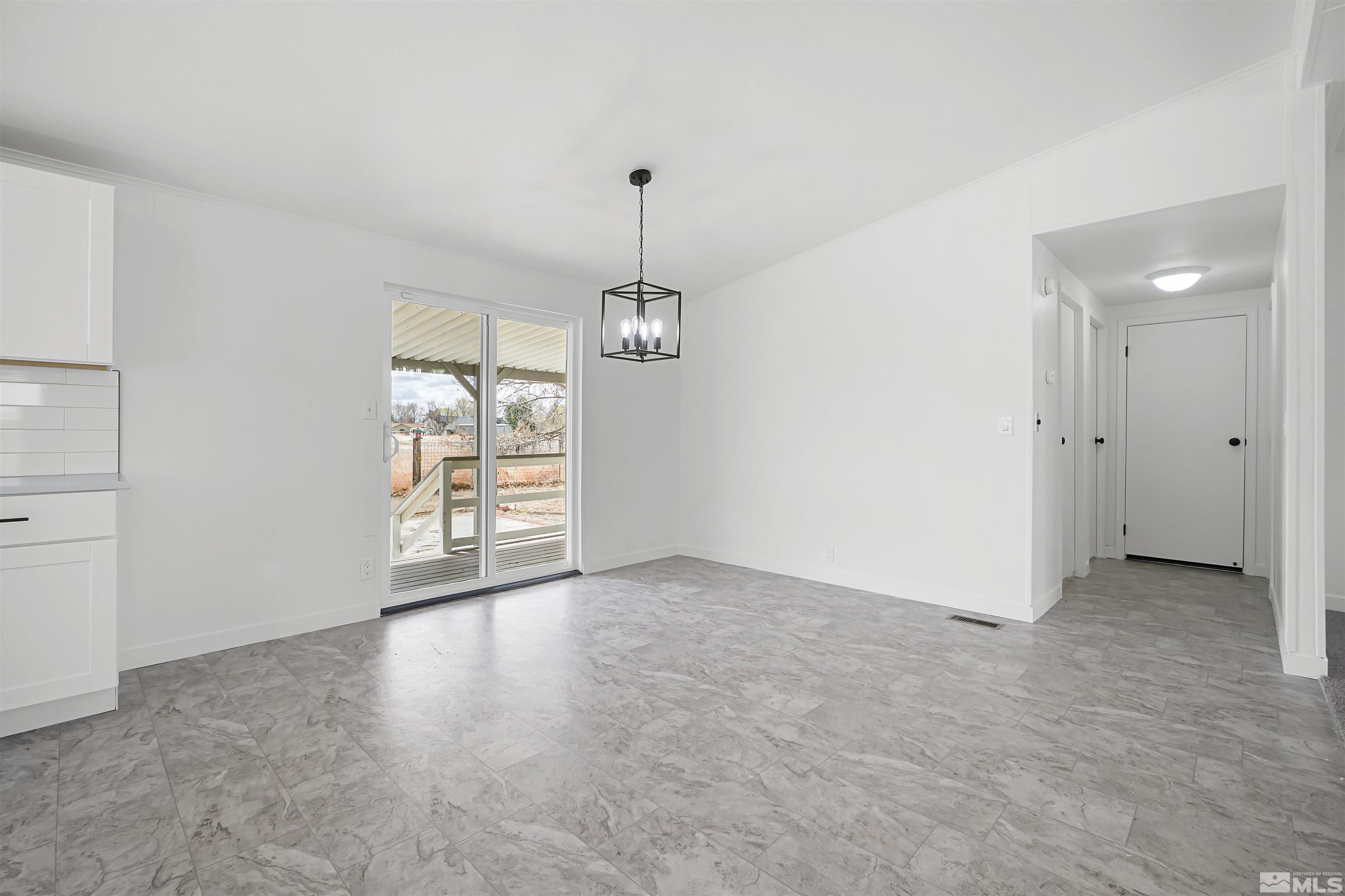 3975 Alcorn Road Fallon, NV 89406 - Photo 8 of 21 an empty room with chandelier fan and windows
