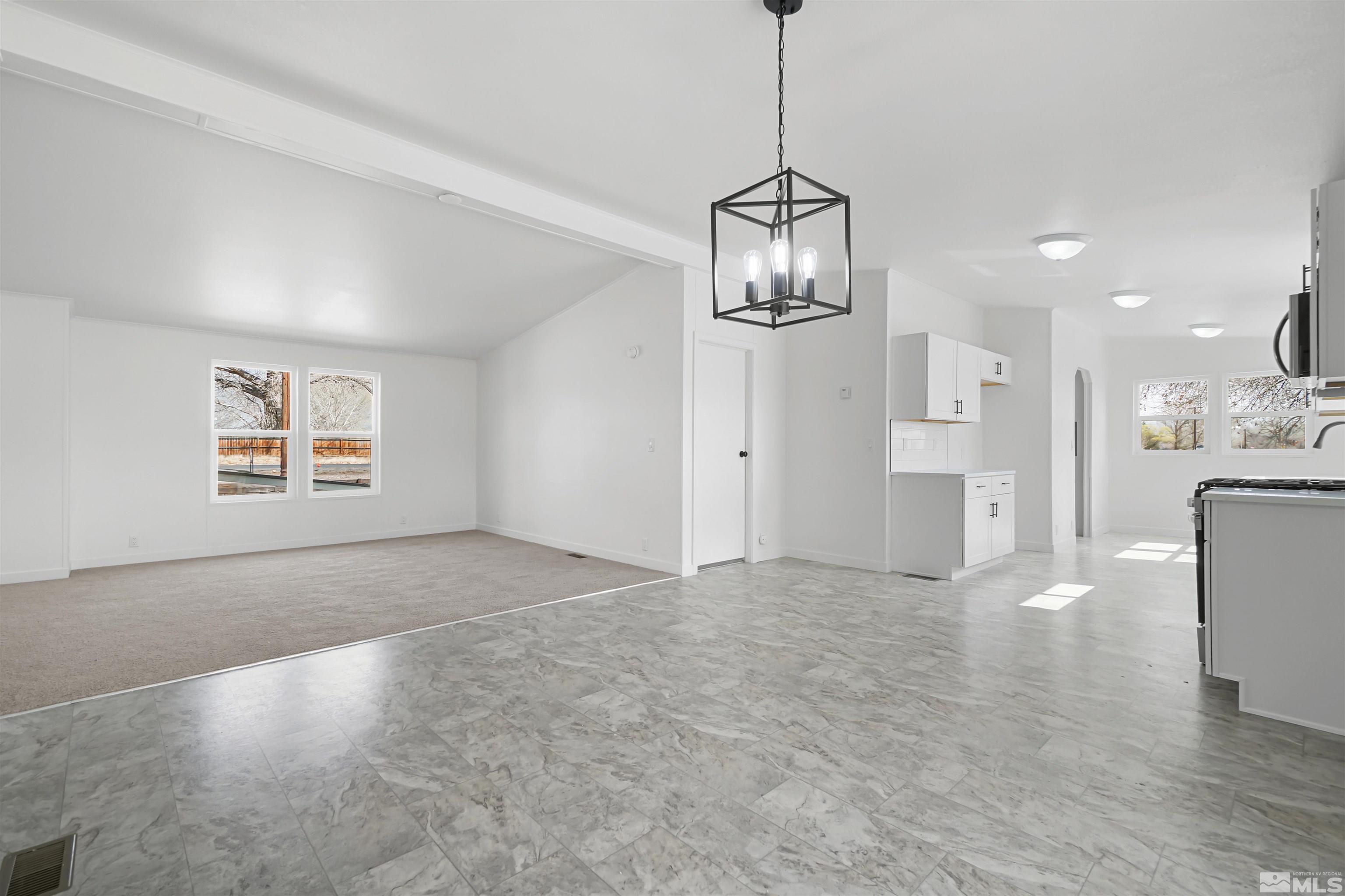 3975 Alcorn Road Fallon, NV 89406 - Photo 9 of 21 a view of empty room with wooden floor and kitchen view