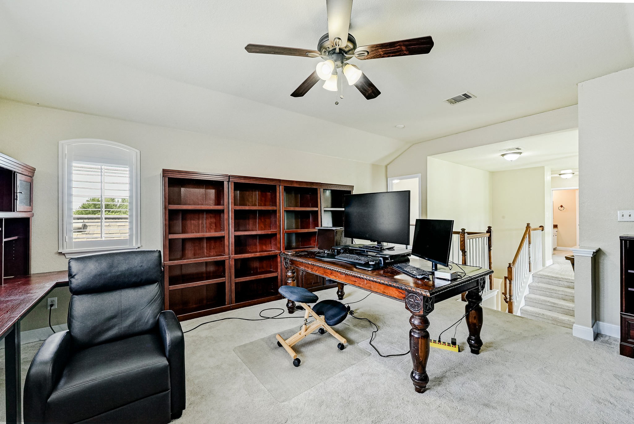 2408 Amen Corner Road Pflugerville, TX 78660 - Photo 25 of 40 Carpeted room featuring a ceiling fan with light fixture, built-in wooden shelving, and a window with plantation shutters