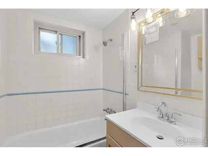 a bathroom with a bathtub a sink and a mirror