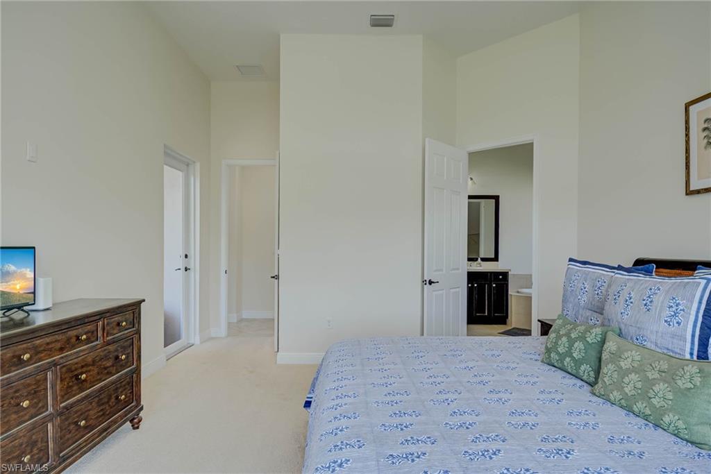 5254 Messina Street Ave Maria, FL 34142 - Photo 15 of 32 a spacious bedroom with a bed and a dresser in it