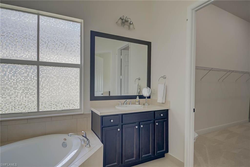 5254 Messina Street Ave Maria, FL 34142 - Photo 18 of 32 a bathroom with a tub a sink and a window