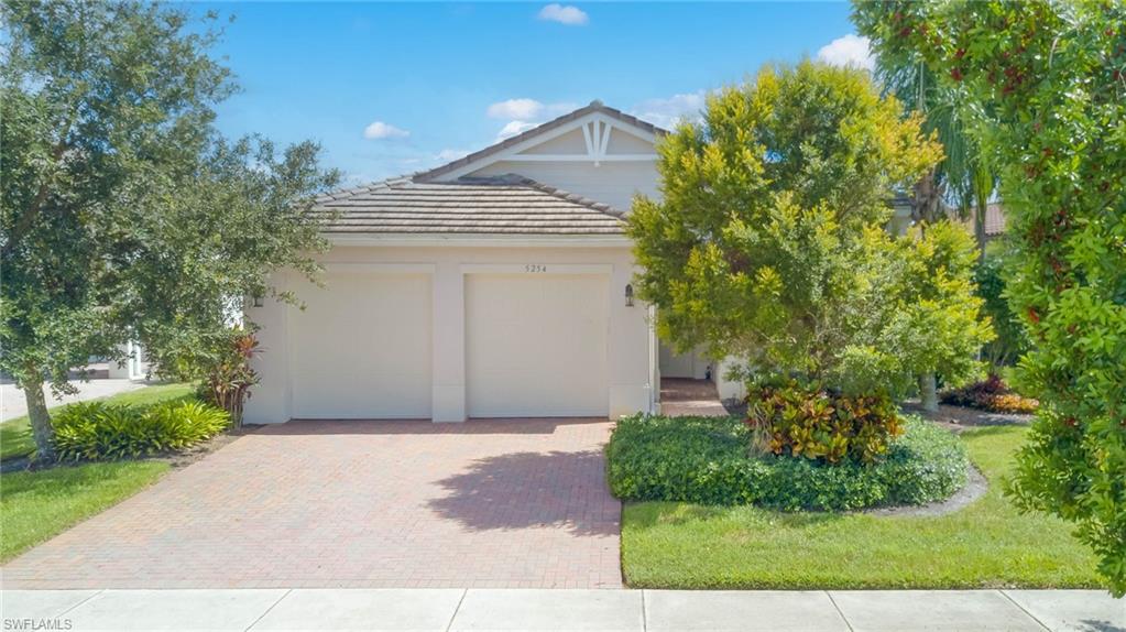 5254 Messina Street Ave Maria, FL 34142 - Photo 2 of 32 a front view of a house with a yard and garage