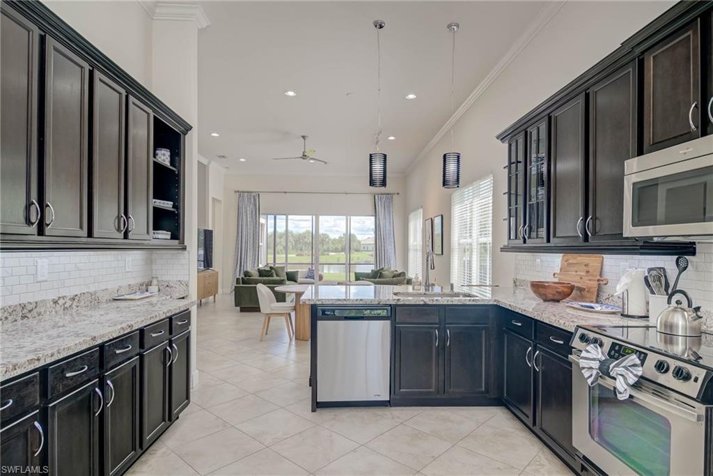 5254 Messina Street Ave Maria, FL 34142 - Photo 10 of 32 a kitchen with stainless steel appliances granite countertop a sink stove and cabinets