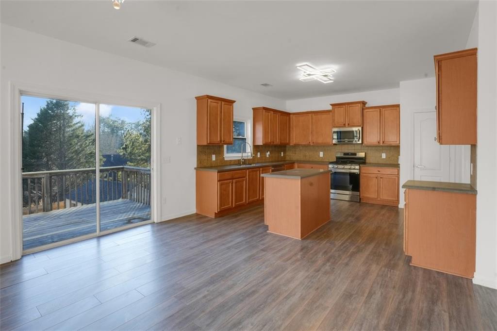5280 Lakerock Way Southwest Atlanta, GA 30331 - Photo 11 of 33 a kitchen with stainless steel appliances granite countertop a stove top oven a sink dishwasher a refrigerator and white cabinets with wooden floor
