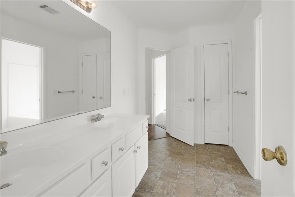 5280 Lakerock Way Southwest Atlanta, GA 30331 - Photo 19 of 33 a spacious bathroom with a granite countertop sink and a mirror
