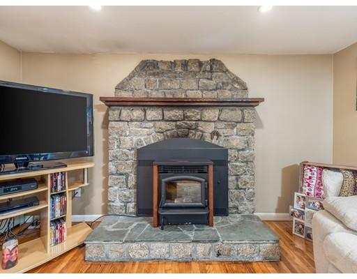 21 Neck Road Rochester, MA 02770 - Photo 8 of 23 a living room with a fireplace and a flat screen tv