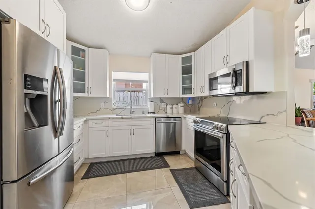 a kitchen with stainless steel appliances a refrigerator sink and cabinets