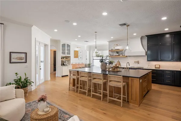 a dining room with stainless steel appliances kitchen island granite countertop a table and chairs in it