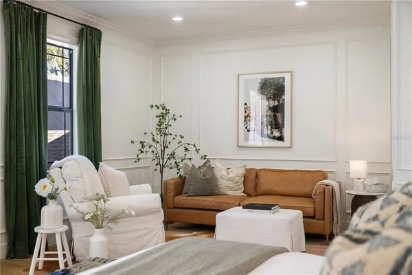 a spacious bedroom with a bed a couch and a large window