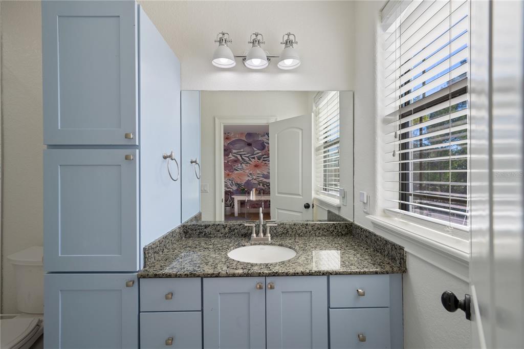 5351 Carson Street St. Cloud, FL 34771 - Photo 29 of 54 a bathroom with a granite countertop sink a mirror and a window