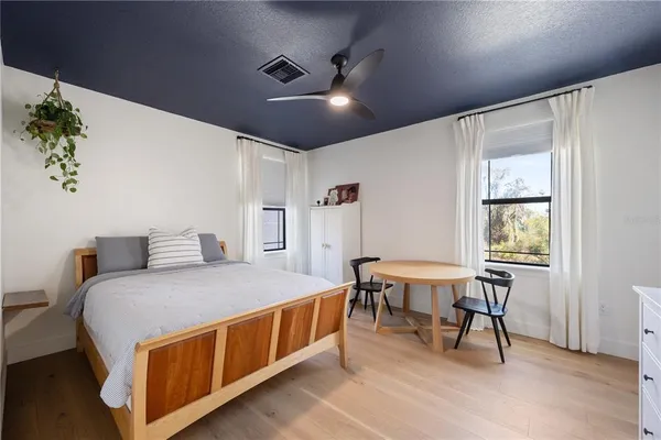 a bedroom with a bed and a potted plant