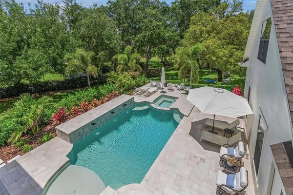 a view of a patio with dining table and chairs with plants and trees