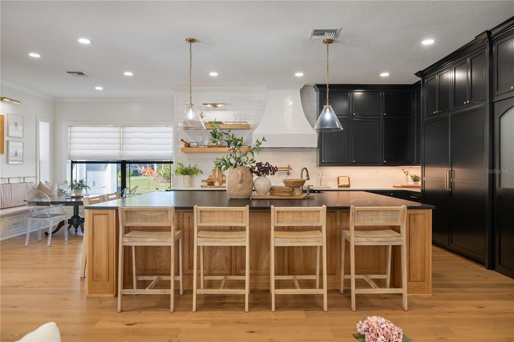 5351 Carson Street St. Cloud, FL 34771 - Photo 6 of 54 a kitchen with kitchen island granite countertop wooden floor cabinets and dining table