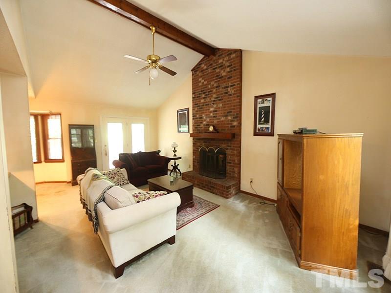 4821 Leven Lane Raleigh, NC 27616 - Photo 3 of 12 a living room with furniture a refrigerator and a fireplace