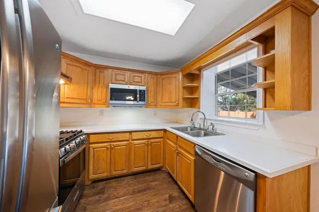 a kitchen with a sink stove and wooden cabinets