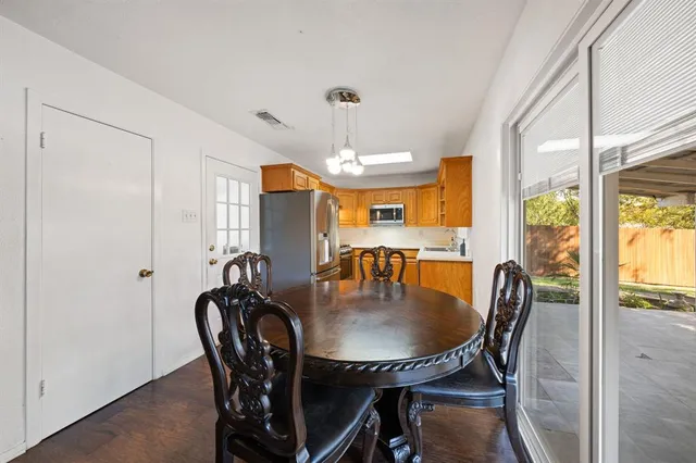 a dining room with furniture a chandelier and wooden floor
