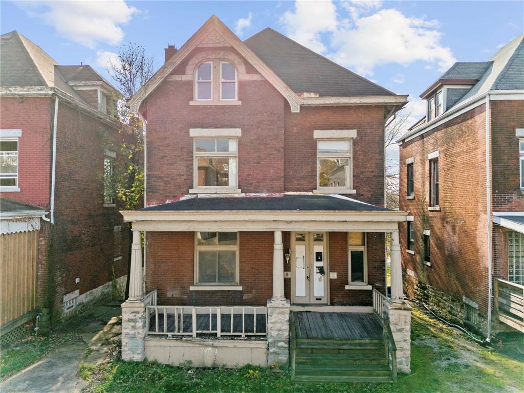 front view of a brick house with a yard