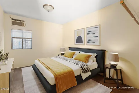 a bedroom with a bed and painting on the wall