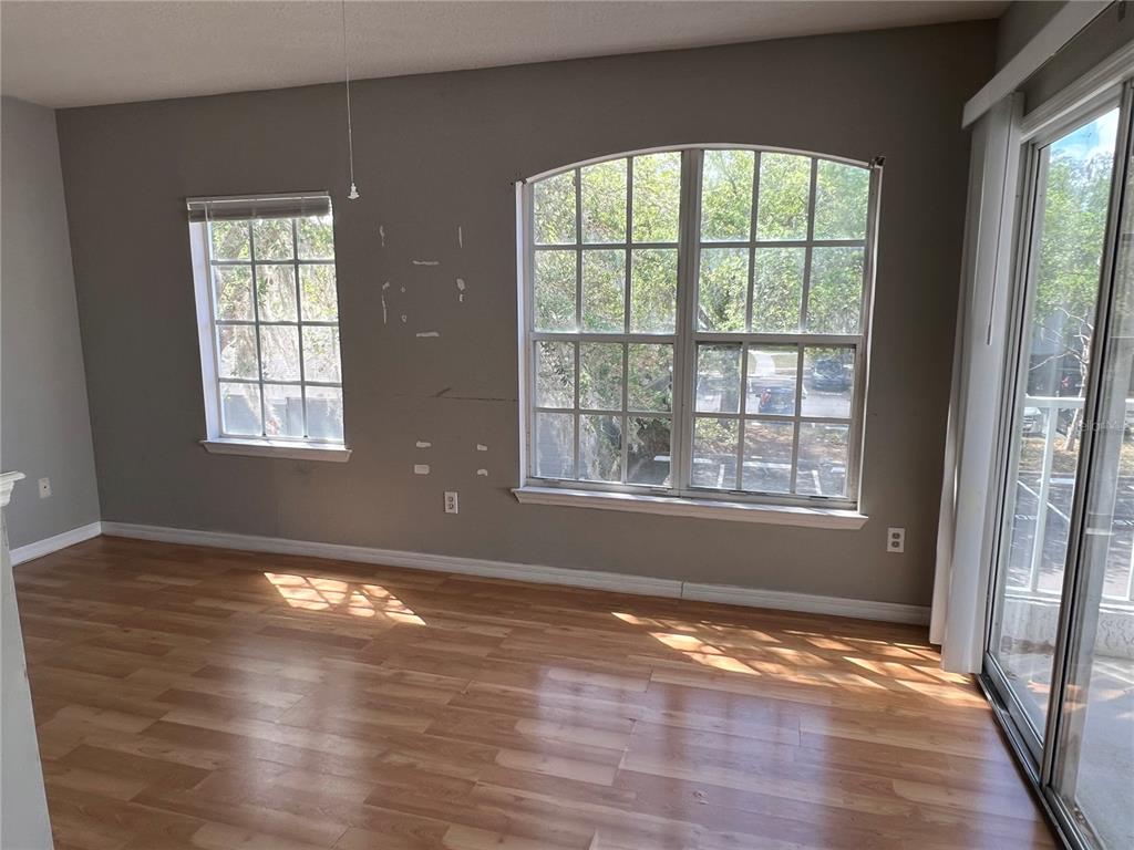 4316 South Kirkman Road, Unit 1604 Orlando, FL 32811 - Photo 5 of 8 a view of an empty room with wooden floor and a window