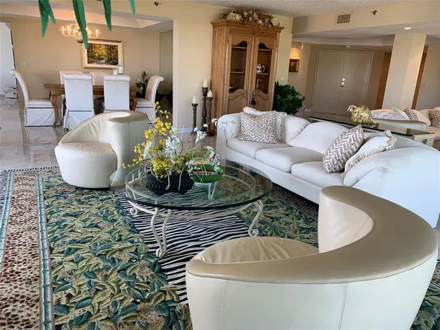 a living room with furniture and a chandelier