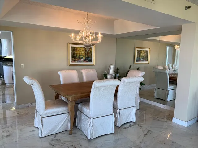 a living room with furniture a chandelier and a dining table