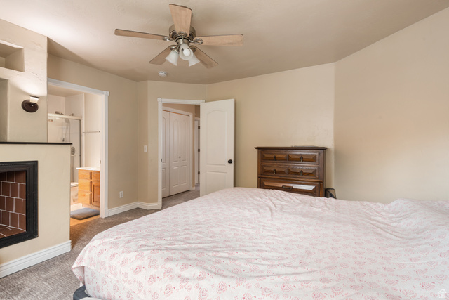 802 Brookside Court Payson, UT 84651 - Photo 23 of 32 Bedroom featuring carpet floors, a ceiling fan, connected bathroom, a fireplace, and a closet