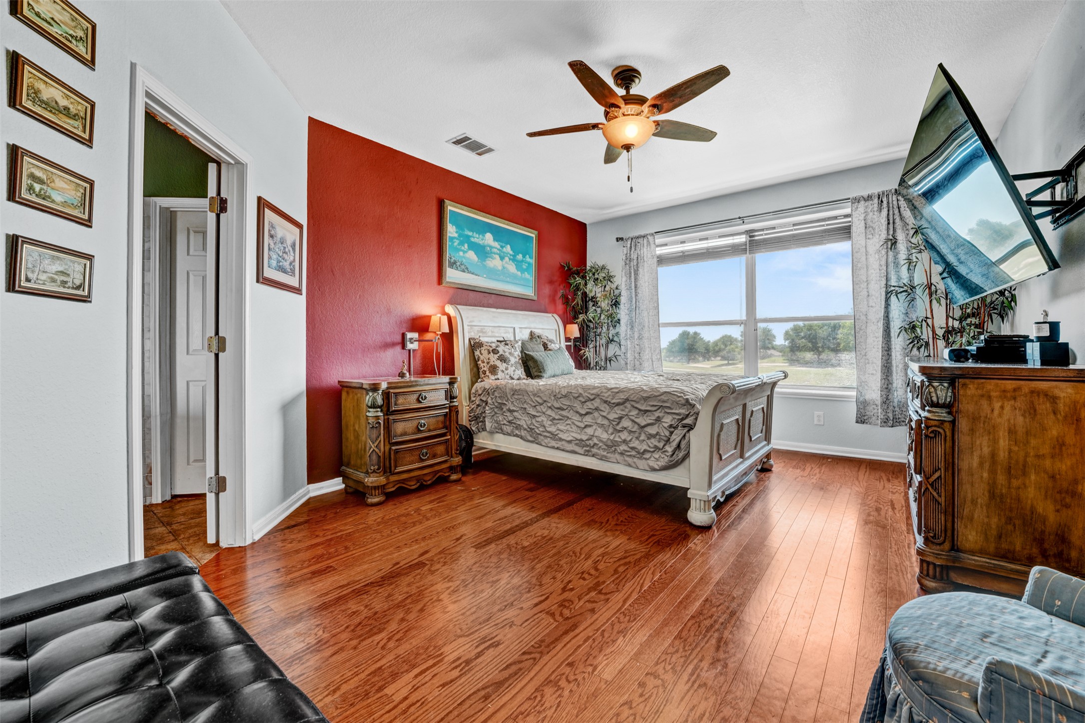 2521 Amen Corner Road Pflugerville, TX 78660 - Photo 13 of 40 Room featuring wood-finish flooring, a ceiling fan with integrated lighting, and a window with exterior visibility