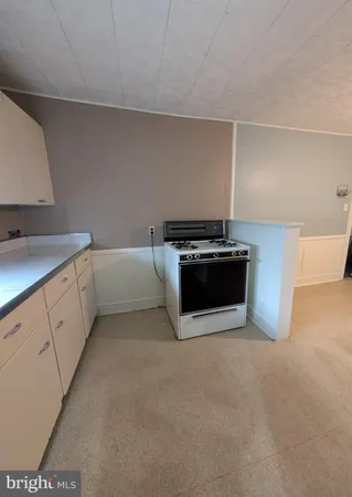 a kitchen with stainless steel appliances a stove and white cabinets