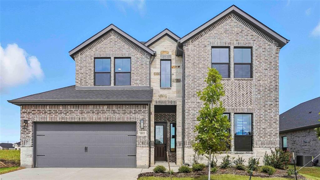 a front view of a house with a yard and garage