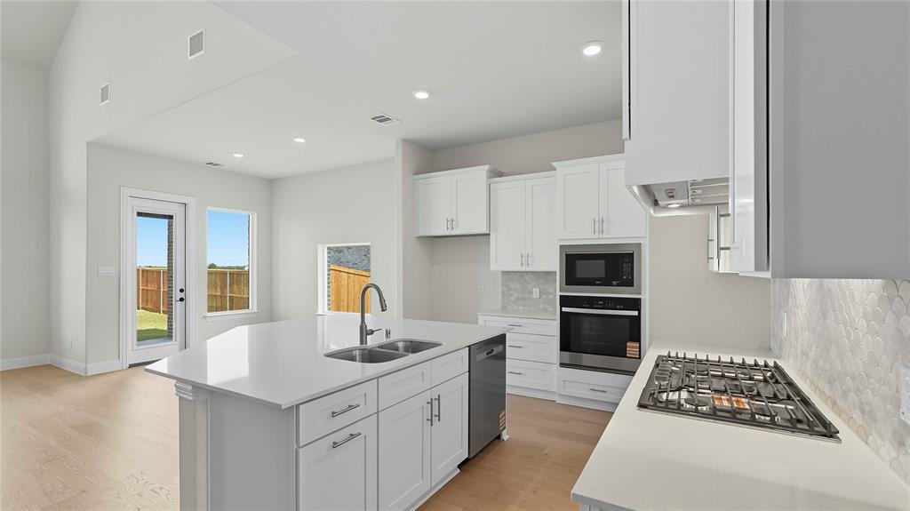 1011 Pitchfork Road Royse City, TX 75189 - Photo 5 of 19 a kitchen with stainless steel appliances a sink a stove a refrigerator cabinets and a dining table