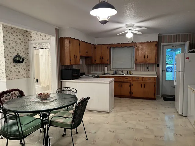 a kitchen with a table chairs refrigerator and cabinets