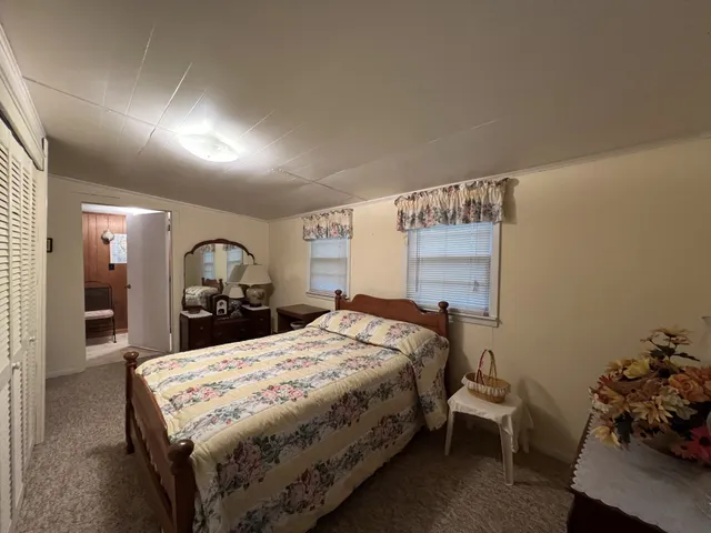 a bed sitting in a bedroom and view of living room