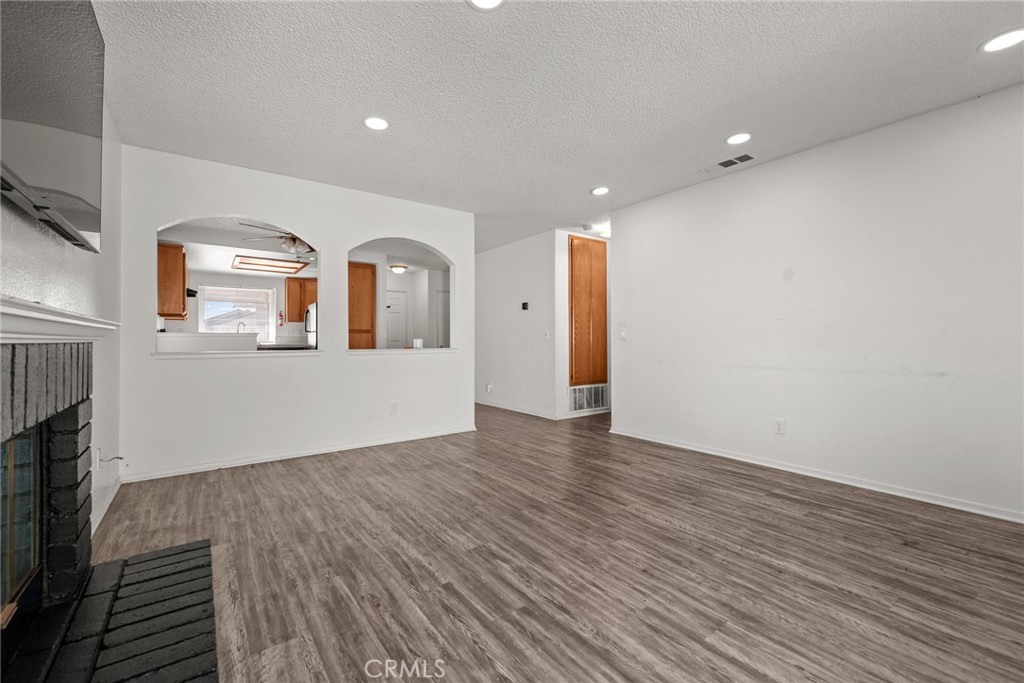 786 Zephyr Circle Hemet, CA 92543 - Photo 17 of 26 a view of empty room with wooden floor and fireplace