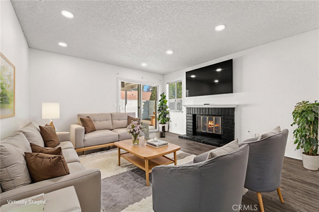786 Zephyr Circle Hemet, CA 92543 - Photo 22 of 26 a living room with furniture a fireplace and a flat screen tv