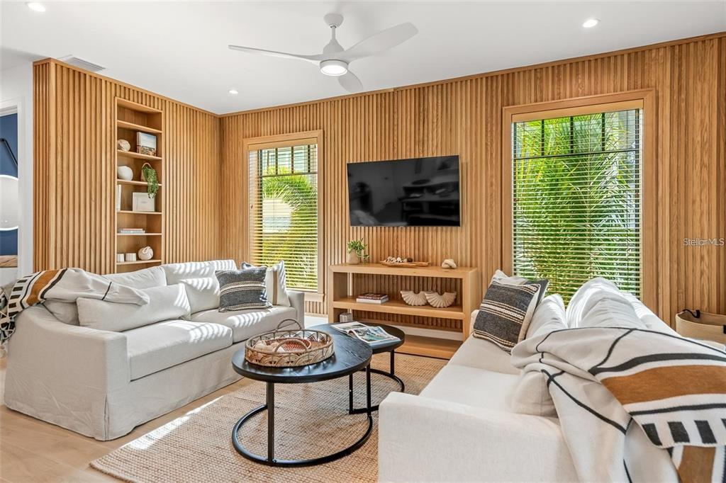 112 Maple Avenue Anna Maria, FL 34216 - Photo 20 of 100 a living room with furniture a flat screen tv and a large window