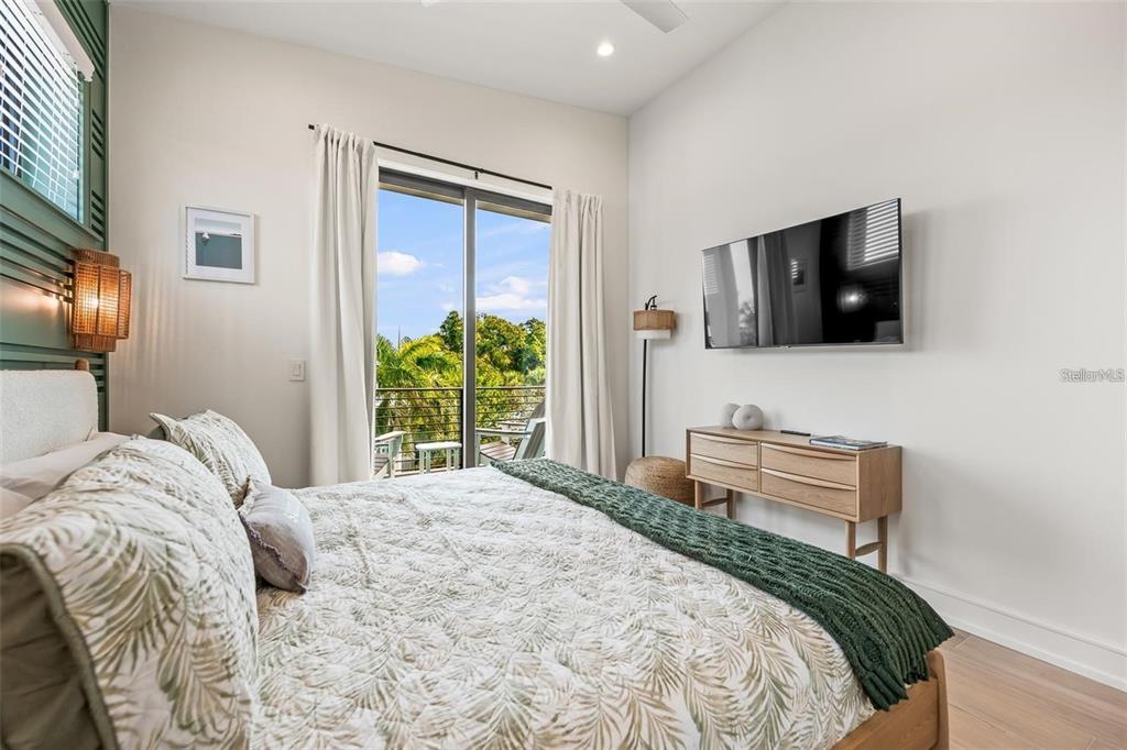 112 Maple Avenue Anna Maria, FL 34216 - Photo 56 of 100 a bedroom with a bed and a flat screen tv