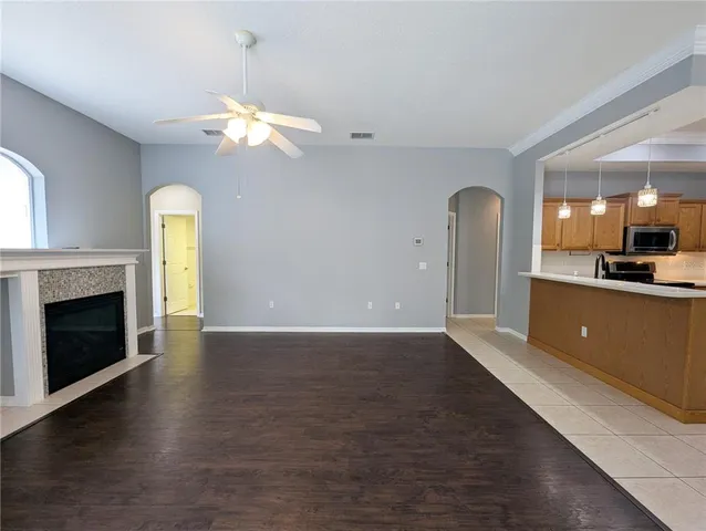 an empty room with wooden floor fireplace and windows