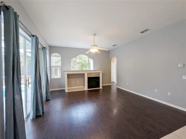 a view of a big room with wooden floor and windows