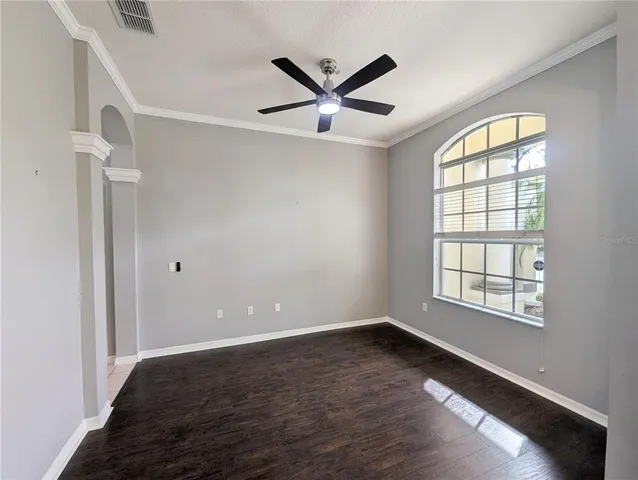 a view of an empty room with a window and wooden floor