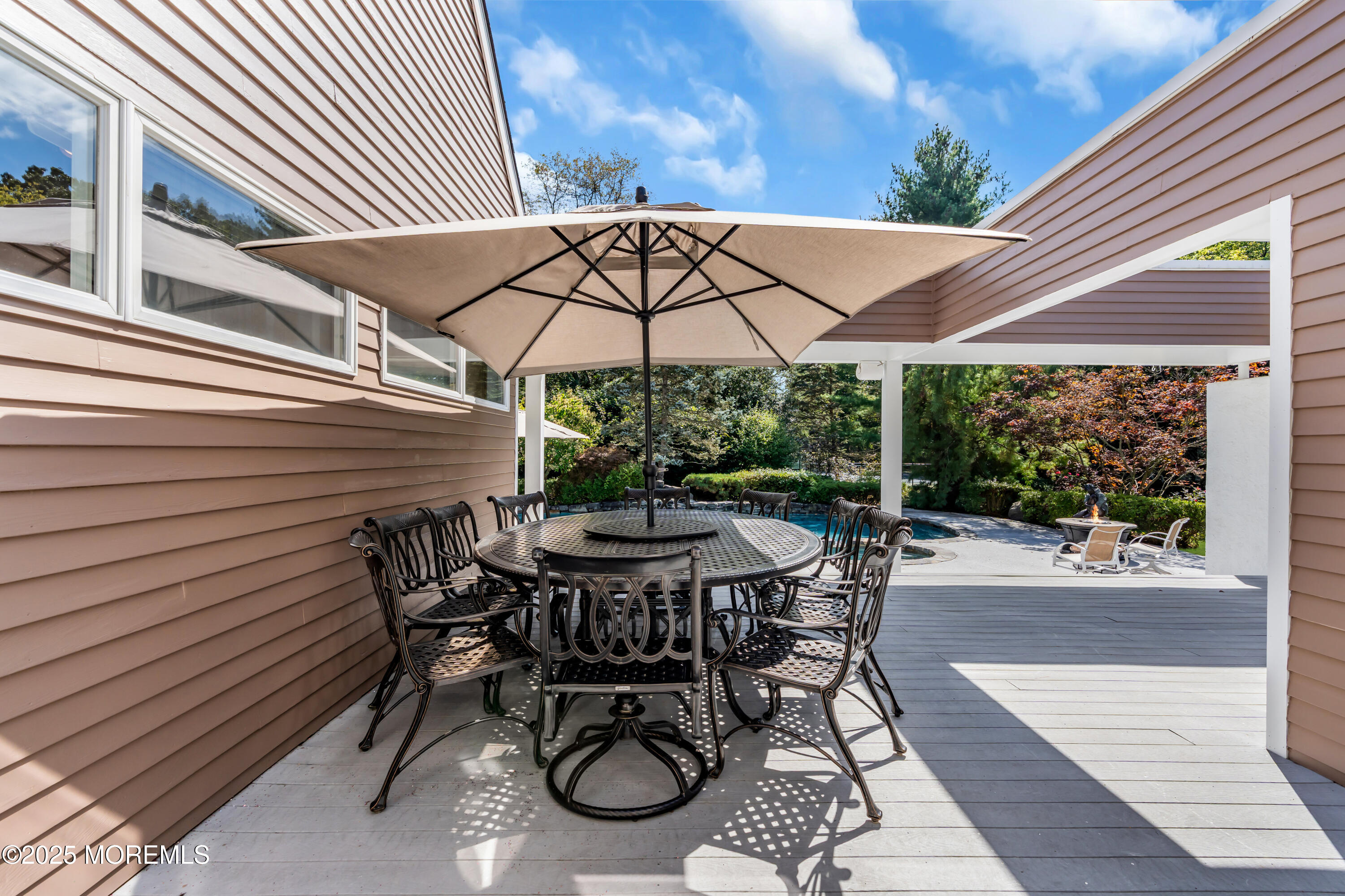 1264 Deal Road Asbury Park, NJ 07712 - Photo 65 of 70 a view of a patio with table and chairs under an umbrella with a small yard