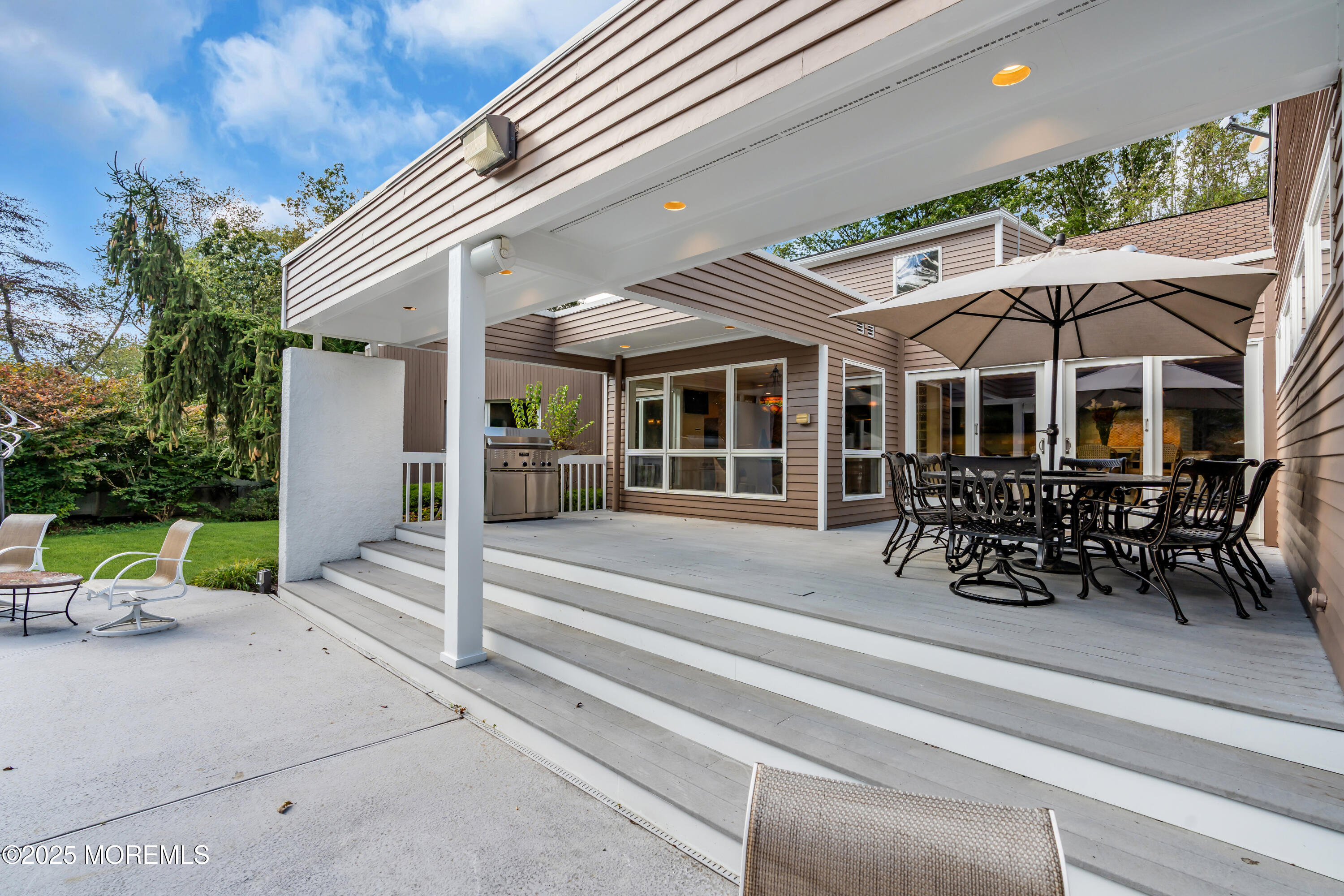 1264 Deal Road Asbury Park, NJ 07712 - Photo 66 of 70 a view of a patio with table and chairs under an umbrella with a barbeque