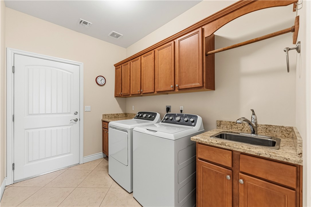 3315 Rainbow Mine Road Kingman, AZ 86401 - Photo 30 of 54 Utility room featuring a sink with a granite countertop, wood cabinetry, and tiled flooring