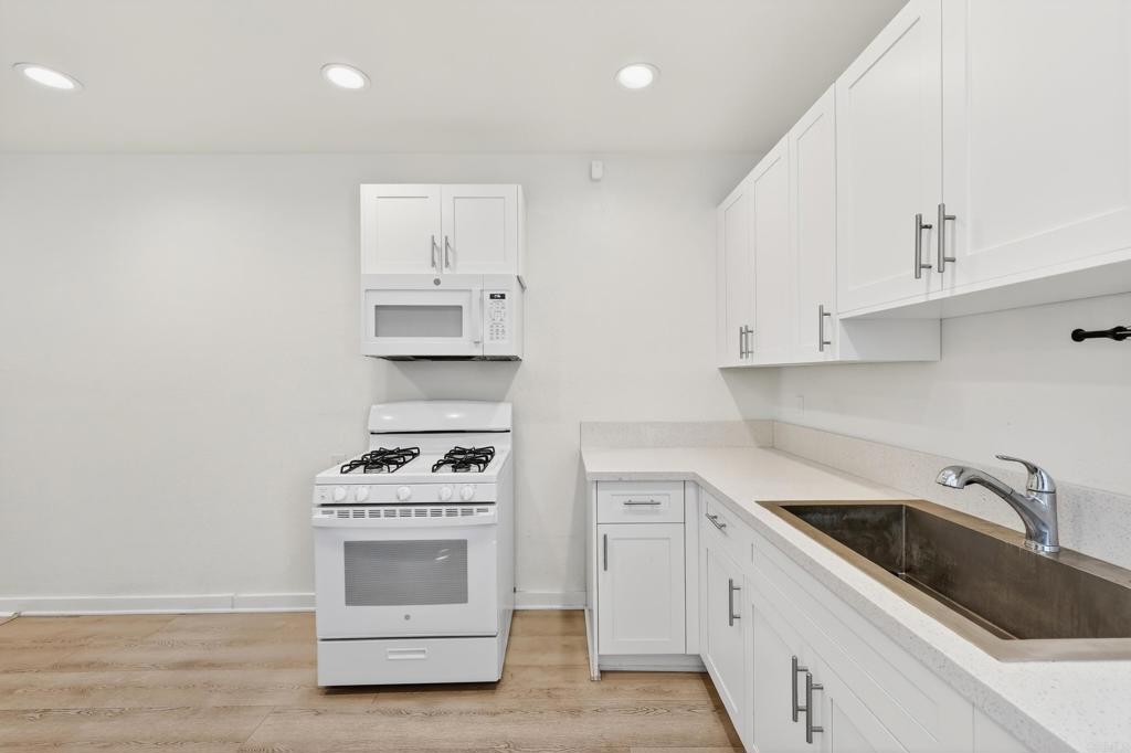 1530 East Appleton Street Long Beach, CA 90802 - Photo 36 of 61 a kitchen with white cabinets and appliances