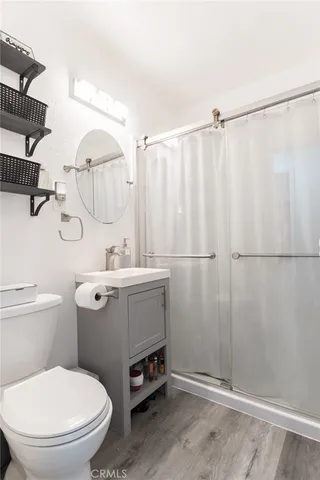 a bathroom with a sink a toilet and shower