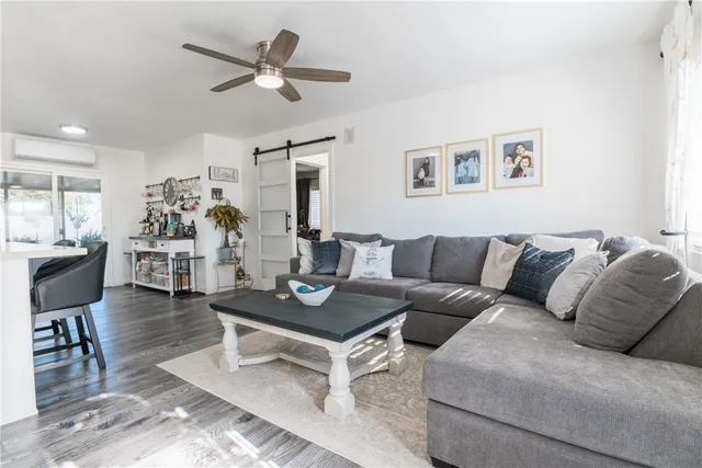 a living room with furniture kitchen view and a chandelier