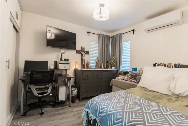 a bedroom with a bed and a flat screen tv