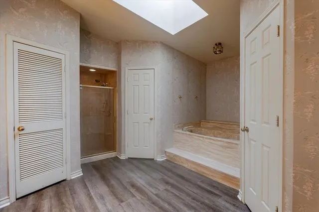 an empty room with wooden floor and a window